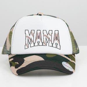 May include: A white trucker hat with a camouflage mesh back. The front of the hat has a white baseball-style graphic with the word "MAMA" in black outlined letters.