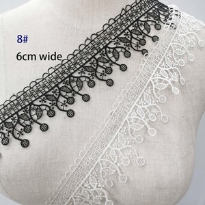 May include: Black and white lace trim, 6cm wide, displayed on a mannequin. The black trim features a geometric and floral design, while the white trim has a delicate floral pattern. The text "8#" and "6cm wide" are visible.
