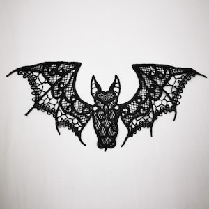 Può includere: Applique a forma di pipistrello in pizzo nero con un design traforato. Il pipistrello ha ali spiegate e un corpo dettagliato, perfetto per Halloween o creazioni gotiche. Ideale per aggiungere un tocco spettrale a vestiti o accessori.