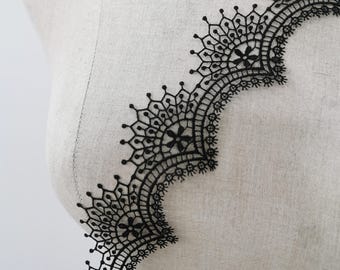 May include: Black lace trim with a scalloped edge and intricate floral designs.