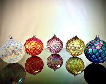 Puede incluir: Cinco adornos de vidrio iridiscente con un patrón de diamante texturizado. Los adornos son en tonos de blanco, rojo, rosa, amarillo y azul.