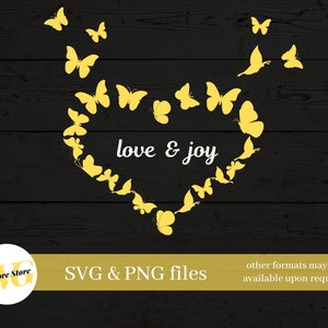 May include: A yellow heart shape made of butterflies with the text "love & joy" inside. The butterflies are on a black wood background.