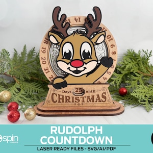 May include: A wooden Rudolph the Red-Nosed Reindeer countdown calendar. The reindeer has a red nose and brown antlers. The calendar counts down to Christmas. The text "Days 25 until Christmas" is visible. The image also includes the text "RUDOLPH COUNTDOWN".