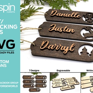 May include: Seven laser-cut wooden gift tags with different designs. The tags are engraved with names like "Danielle", "Justin", and "Darryl". The designs include a snowflake, a reindeer, and a pine tree.