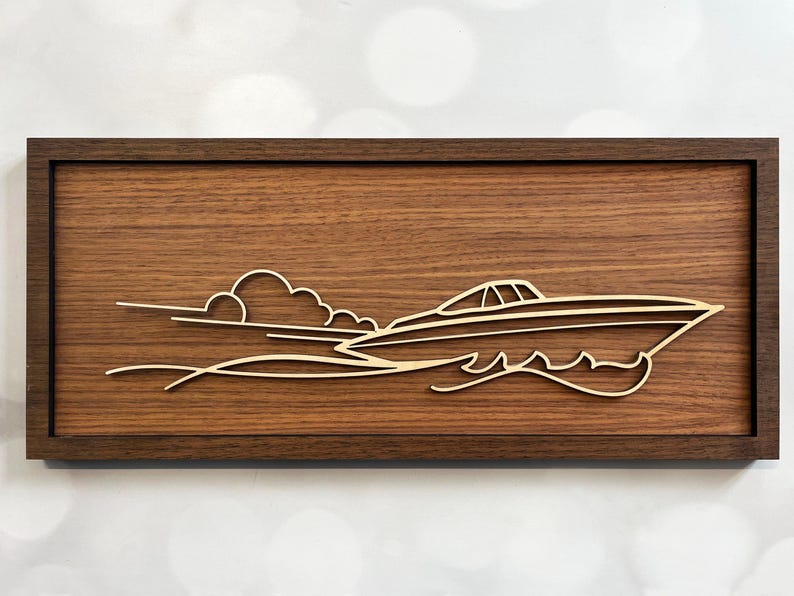 May include: A wooden wall art piece with a cutout design of a boat speeding through the water with a cloud in the background.