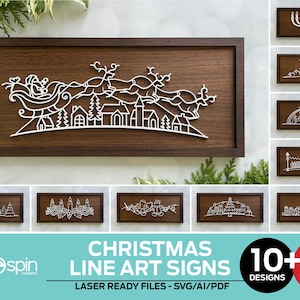 May include: A collection of Christmas line art signs. The main sign features a white laser-cut design of Santa Claus in a sleigh pulled by reindeer over a village, set against a dark wood background. Additional designs are also shown.