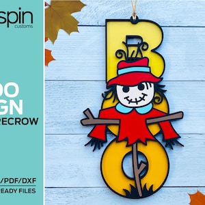 May include: A yellow letter "B" with a scarecrow face and red hat. The scarecrow is holding a stick with a brown base. The letter is on a light blue wooden background.  "BOO SIGN SCARECROW" and "SVG/AI/PDF/DXF LASER READY FILES" are written in black text on a teal background.