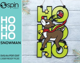 May include: A green wooden sign with the word "HO" repeated three times. A cartoon reindeer with a red scarf and a bell is running across the sign. The sign is hanging on a white wooden wall.