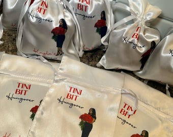 May include: White satin drawstring bags with the text "Tini Bit Hungover" in red and black. Each bag features an illustration of a woman holding red roses and the text "Kayla's 33rd Birthday".