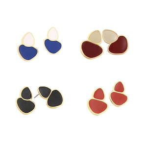 May include: Four pairs of abstract geometric shaped earrings. The earrings are made of gold metal and have a variety of colors, including black, white, red, and blue.