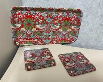 May include: A set of three red and green coasters with a floral pattern. The coasters are made of a hard material and have a glossy finish.