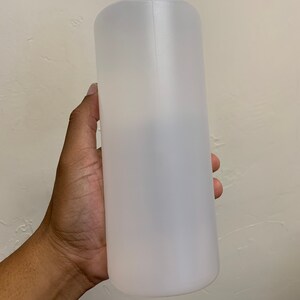 May include: A clear plastic bottle with a white cap. The bottle is empty and has a smooth, cylindrical shape.