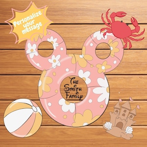 May include: A pink floral Mickey Mouse-shaped design with a crab, beach ball, and sandcastle. The design includes the text "The Smith Family" and "Personalize your message". The background is a wood grain.