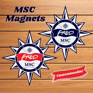 May include: Two navy blue and white compass rose magnets with the text "FRED" on a red banner. The magnets also feature the text "MSC Cruises" and "Customizable!". The background is a wooden surface.