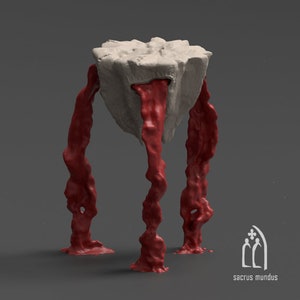 Puede incluir: Una escultura blanca con forma de roca con un agujero en la parte superior, del que gotea una sustancia roja viscosa. La escultura está sostenida por tres patas rojas de forma orgánica.