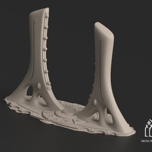 Könnte beinhalten: Ein 3D-gedrucktes Modell einer futuristischen, abstrakten Skulptur mit zwei hohen, schlanken Türmen, die durch eine Basis verbunden sind. Die Türme haben eine Reihe von kreisförmigen Details und die Basis hat eine strukturierte Oberfläche.