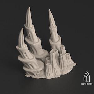 Puede incluir: Una miniatura impresa en 3D de una formación rocosa de fantasía con altas torres puntiagudas y formaciones más pequeñas y redondeadas. La roca es de color gris claro y tiene una superficie texturizada.