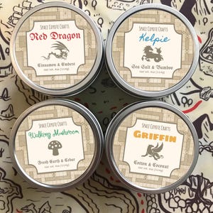 Può includere: Quattro barattoli rotondi in metallo con etichette. Le etichette recitano "Red Dragon", "Kelpie", "Walking Mushroom" e "Griffin". Ogni barattolo ha un profumo diverso, con un peso netto di 114g. Lo sfondo è una mappa.