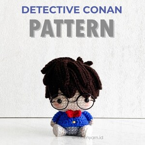 May include: Crochet pattern for a Detective Conan amigurumi doll. The doll is wearing a blue jacket, a red bow tie, and glasses. The pattern is available for download.