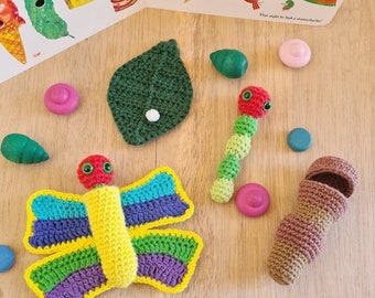 May include: A selection of crocheted toys based on "The Very Hungry Caterpillar". The set features a vibrant butterfly, a caterpillar, a leaf, and a cocoon, plus colourful wooden circles and a book page.