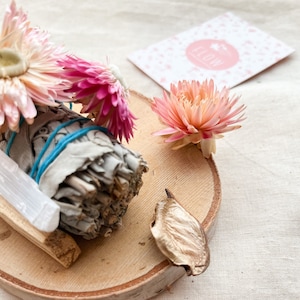 Mancha de salvia blanca y flores silvestres con Palo Santo en palo y cristal de selenita