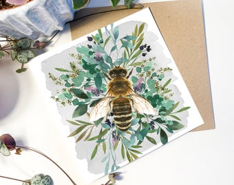May include: A watercolor illustration of a bee surrounded by green leaves and flowers on a white background. The bee is brown and yellow with black stripes. The leaves are green and the flowers are purple and white.