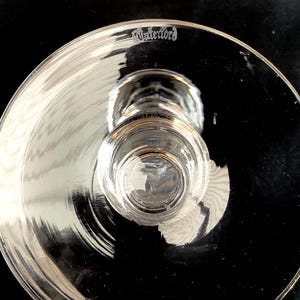 K&ouml;nnte beinhalten: Nahaufnahme der Unterseite eines klaren Glases mit Stiel, auf dem unten das Waterford-Logo einge&auml;tzt ist.