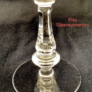K&ouml;nnte beinhalten: Ein klares Glasgoblet mit einem geschliffenen Kristallstiel und einem runden Fu&szlig;. Das Goblet steht auf einer schwarzen Oberfl&auml;che. Etsy Glasneyinteriors.