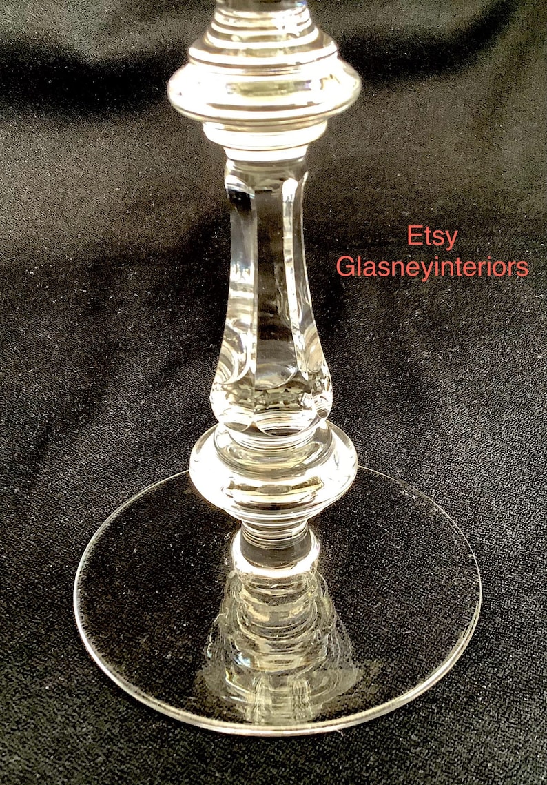 K&ouml;nnte beinhalten: Ein klares Glasgoblet mit einem geschliffenen Kristallstiel und einem runden Fu&szlig;. Das Goblet steht auf einer schwarzen Oberfl&auml;che. Etsy Glasneyinteriors.