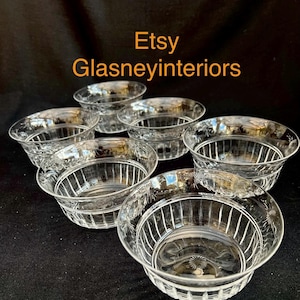 Può includere: Set di sette ciotole in vetro trasparente con motivi floreali incisi e linee verticali. Le ciotole hanno una forma arrotondata con un bordo leggermente svasato. Il testo "Etsy Glasneyinteriors" è visibile.