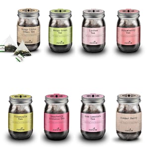 May include: Eight glass jars with metal lids containing loose leaf tea. The jars are labeled with the tea flavors: Honey Citrus Green Tea, Mango Green Tea, Lychee Tea, Strawberry Tea, Pineapple Tea, Raspberry Hibiscus Tea, Rose Lemonade Tea, and Summer Berry Tea. The jars are arranged in two rows of four.