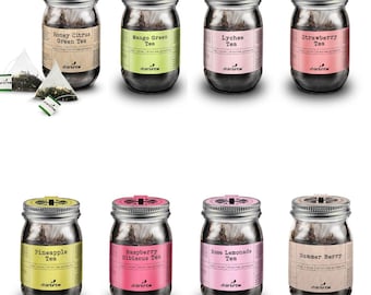 May include: Eight glass jars with metal lids containing loose leaf tea. The jars are labelled with the tea flavours: Honey Citrus Green Tea, Mango Green Tea, Lychee Tea, Strawberry Tea, Pineapple Tea, Raspberry Hibiscus Tea, Rose Lemonade Tea, and Summer Berry Tea. The jars are arranged in two rows of four.