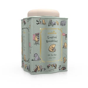 Puede incluir: Una lata de metal verde con temática de Winnie the Pooh. La lata tiene una tapa rosa claro y presenta ilustraciones de Winnie the Pooh y sus amigos. El texto en la lata dice "charbrew English Breakfast 100 Tea Bags 200g / 7.05oz".