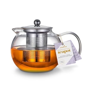 Peut inclure: Une théière en verre transparent avec un couvercle et une passoire en acier inoxydable. La théière a une capacité de 500 ml ou 3 tasses. La théière est remplie de thé orange. L'étiquette sur la théière indique "chairbrew Borosilicate Glass Teapot Authentic Chinese Borosilicate Glass Teapot 500ml / 3 Cups"