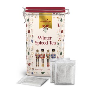 Puede incluir: Una lata rectangular de té de especias de invierno con tapa roja y cierre plateado. La lata presenta un fondo crema con un diseño festivo y las palabras "Winter Spiced Tea". La lata contiene 60 bolsitas de té.