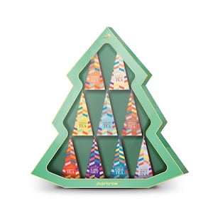 Puede incluir: Una caja de regalo verde en forma de árbol de Navidad llena de diez paquetes de té coloridos. Cada paquete es triangular y presenta una variedad de té diferente, incluyendo "Té Chai" y "Té Vainilla". La marca "charbrew" está impresa en la parte inferior.