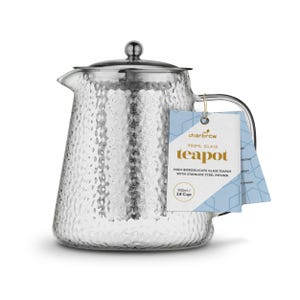 Peut inclure: Une théière en verre transparent avec une surface texturée et un infuseur en acier inoxydable. La théière a un couvercle et une poignée argentés. L'étiquette indique "charbrew teapot" et une capacité de 900 ml.