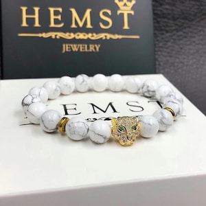 Bracelet made of natural stone cacholong with a panther of golden color