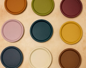 Peut inclure: Neuf dessous de verre ronds et colorés, dans des tons d'orange, de vert, de bordeaux, de rose, de sarcelle, de jaune, de marine, de crème et de marron. Les dessous de verre sont disposés en grille 3x3.
