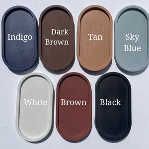 May include: Seven oval-shaped trays arranged in two rows. The top row features colours labelled Indigo, Dark Brown, Tan, and Sky Blue. The bottom row features colours labelled White, Brown, and Black. Each tray has a smooth, solid-coloured surface.