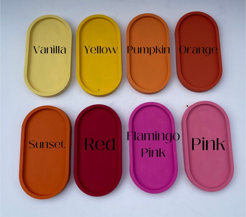May include: Eight oval-shaped trays arranged in two rows, labelled with text: Vanilla, Yellow, Pumpkin, Orange, Sunset, Red, Flamingo Pink, and Pink. Each tray features a solid, matte-finish colour corresponding to its label, showcasing a smooth surface.
