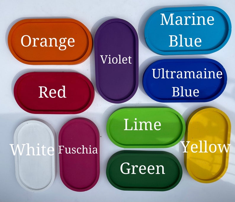 May include: A collection of eleven oval trays in various solid colours including orange, violet, marine blue, red, ultramarine blue, white, fuschia, lime, green, and yellow, each labelled with its corresponding colour name in white text.