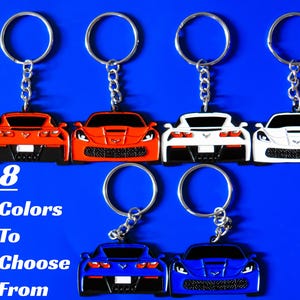 May include: Six metal keychains shaped like sports cars in red, white, and blue, featuring both front and rear views. Each keychain has a silver split ring and chain. The text 8 Colors To Choose From is printed in white on the left side.