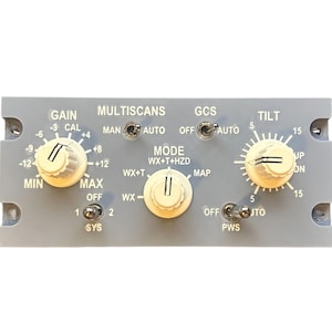 Peut inclure: Un panneau de contrôle rectangulaire gris étiqueté MULTISCANS avec trois boutons rotatifs crème pour les réglages GAIN, MODE et TILT, ainsi que quatre interrupteurs à bascule en métal pour les paramètres MAN/AUTO, GCS, SYS 1/2 et PWS.
