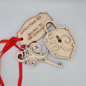 May include: A wooden Santa's Magic Key ornament with a key and padlock, with the text "Santa's Magic Key Belongs To The Robertsons" on a tag. The ornament is tied with a red ribbon.