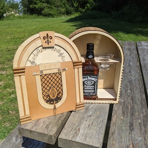 Peut inclure: Une boîte en bois en forme de juke-box vintage avec une bouteille de whisky Jack Daniel's Tennessee et deux verres à shot à l'intérieur.