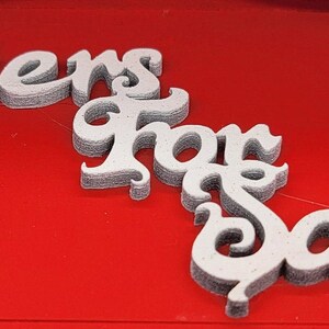 May include: White letters spelling "Letters for Santa" on a red background.