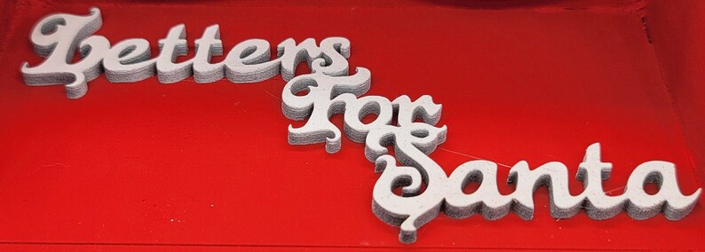 May include: White letters spelling "Letters for Santa" on a red background.