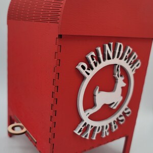 May include: Red wooden box with a white reindeer and the words "Reindeer Express" on the side. The box has a small wooden handle on the front.