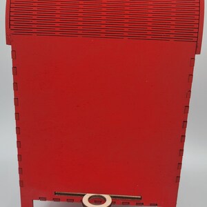 May include: Red wooden mailbox with a decorative top and a small wooden handle. The mailbox is on four legs.